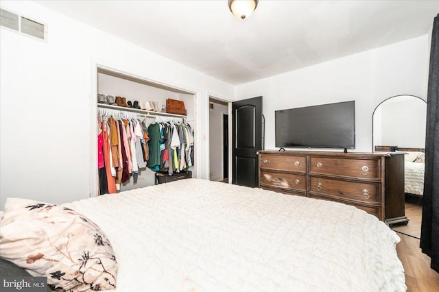 bedroom featuring a closet, wood finished floors, and visible vents