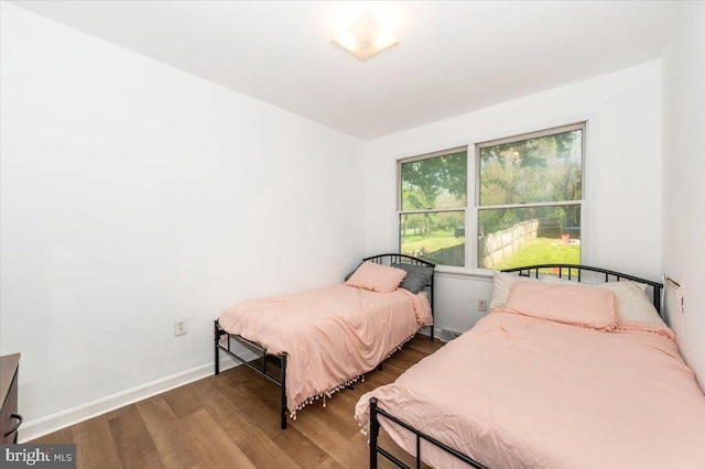 bedroom with baseboards and wood finished floors