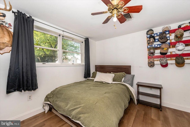 bedroom featuring baseboards, a ceiling fan, and wood finished floors