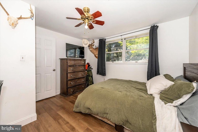 bedroom with baseboards, ceiling fan, and wood finished floors