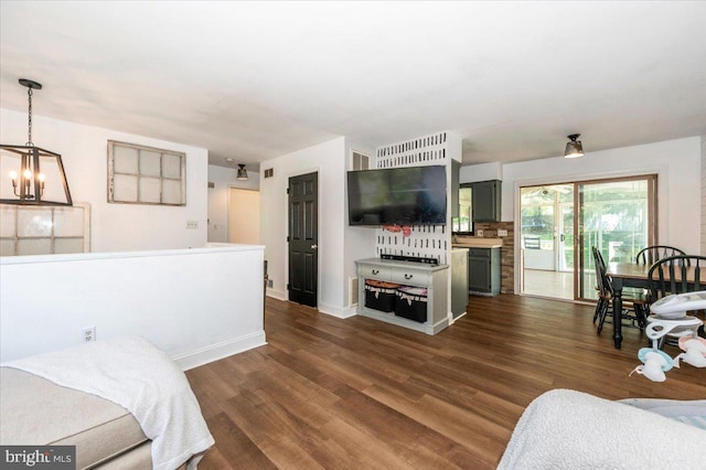 living room with baseboards, an inviting chandelier, dark wood finished floors, and visible vents