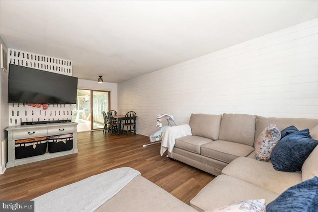 living area featuring brick wall and wood finished floors