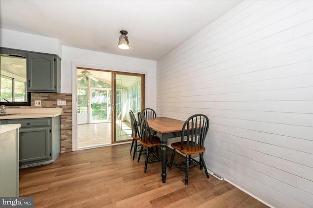 dining space with wood finished floors and wooden walls