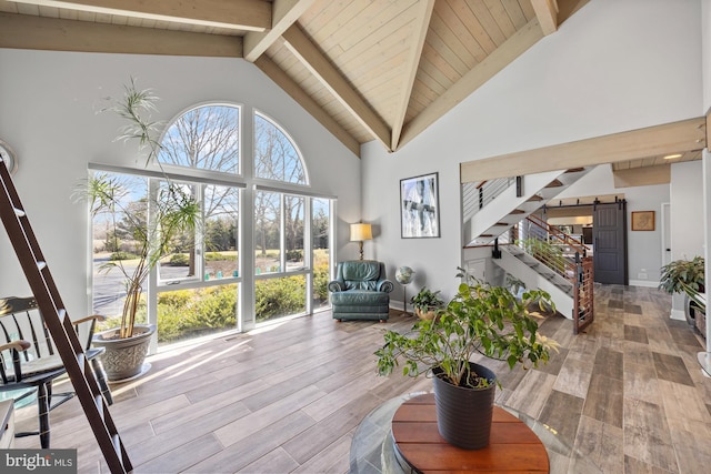 living area with baseboards, stairway, beamed ceiling, wood finished floors, and high vaulted ceiling