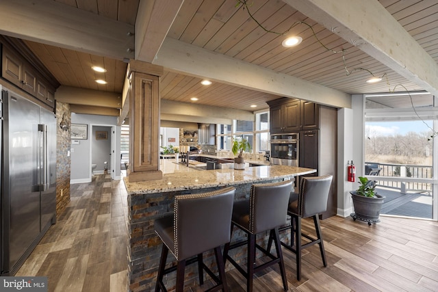 kitchen featuring stainless steel appliances, plenty of natural light, beam ceiling, and wooden ceiling