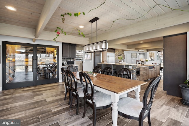 dining space with wood finished floors, beam ceiling, recessed lighting, french doors, and wooden ceiling