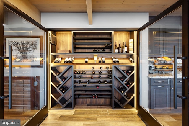 wine cellar featuring wooden ceiling, beamed ceiling, and light wood-type flooring