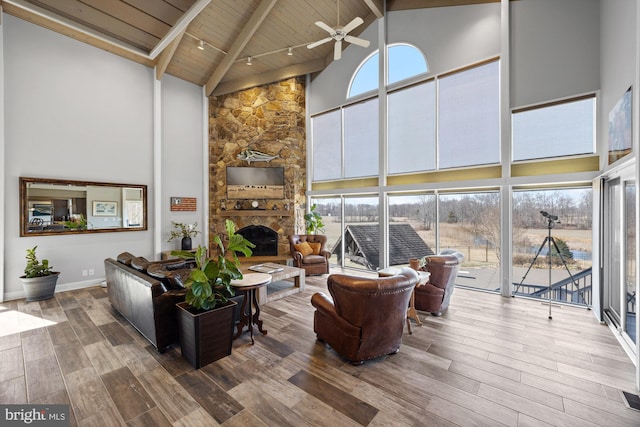 living area featuring a healthy amount of sunlight, ceiling fan, wooden ceiling, wood finished floors, and high vaulted ceiling