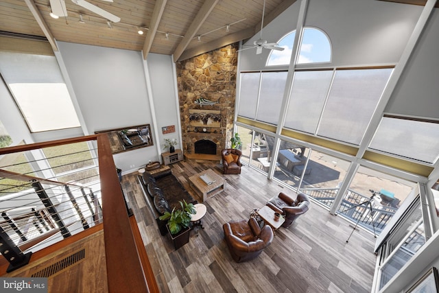 living room featuring ceiling fan, wood ceiling, beam ceiling, wood finished floors, and high vaulted ceiling