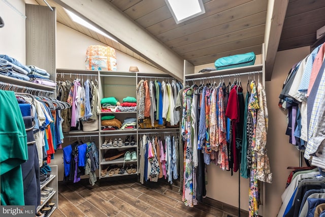 spacious closet featuring wood finish floors, beam ceiling, and a skylight