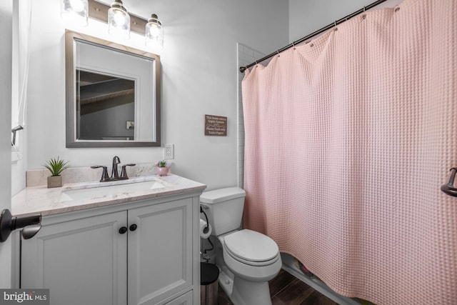 full bath with vanity, a shower with shower curtain, toilet, and wood finished floors