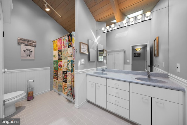 bathroom featuring a wainscoted wall, wooden ceiling, and a sink