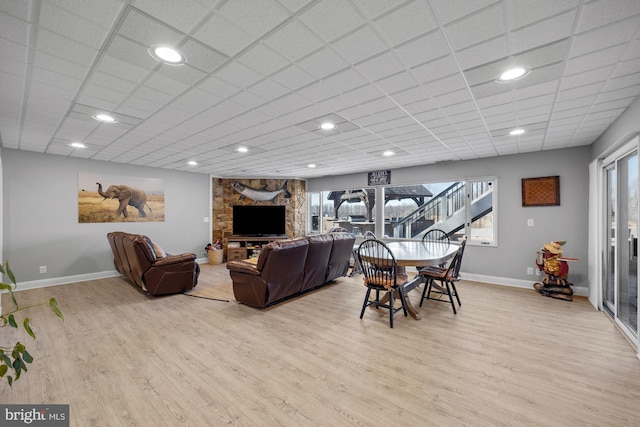 living area with a paneled ceiling, light wood-type flooring, baseboards, and recessed lighting