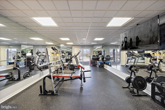 workout area with a drop ceiling and baseboards