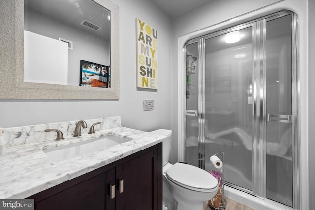 full bath with visible vents, toilet, a stall shower, and vanity