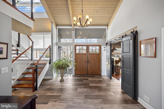 foyer entrance with stairs, dark wood finished floors, baseboards, and a chandelier