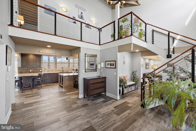 entrance foyer with visible vents, baseboards, wood finished floors, and stairs