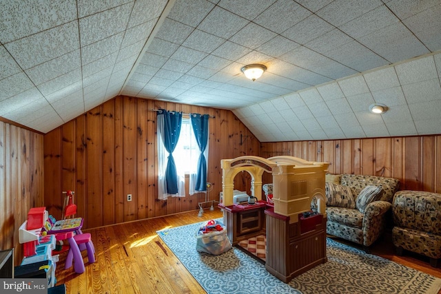 rec room with wood walls, lofted ceiling, and wood finished floors