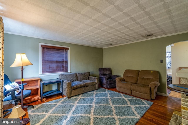 living room featuring baseboards, arched walkways, wood finished floors, and crown molding