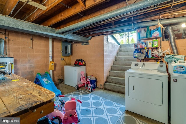 basement featuring washer and dryer, fridge, stairway, and electric panel