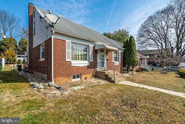 bungalow with brick siding, a chimney, and a front yard