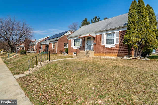 view of front of house featuring brick siding, a residential view, and a front lawn