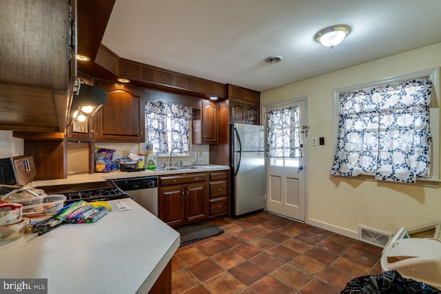 kitchen featuring a healthy amount of sunlight, visible vents, a sink, light countertops, and appliances with stainless steel finishes