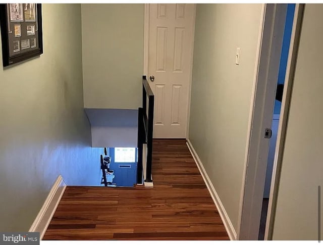 hall featuring baseboards and wood finished floors