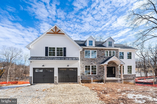 view of front of property with stone siding, an attached garage, and driveway