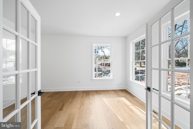 unfurnished room with recessed lighting, french doors, baseboards, and light wood finished floors