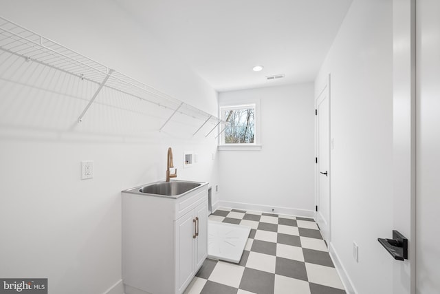 laundry room featuring visible vents, a sink, cabinet space, light floors, and hookup for a washing machine