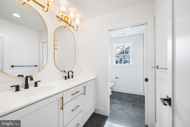 full bathroom with tile patterned flooring, double vanity, toilet, and a sink