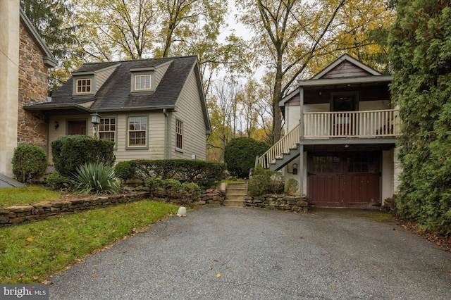 view of home's exterior featuring stairs, aphalt driveway, and a garage