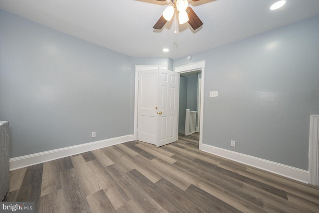 interior space featuring wood finished floors, baseboards, and ceiling fan