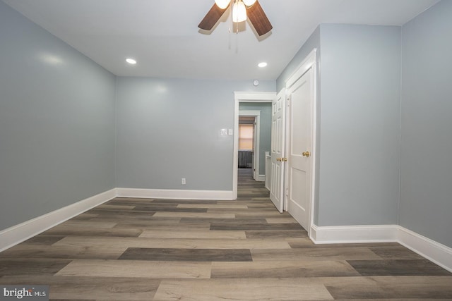 spare room with a ceiling fan, recessed lighting, wood finished floors, and baseboards