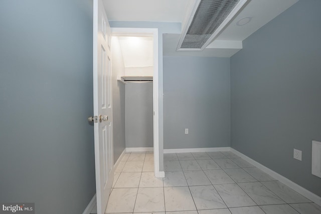 laundry area with marble finish floor and baseboards