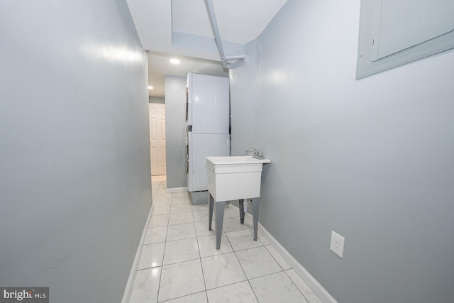 hall with electric panel, baseboards, and marble finish floor