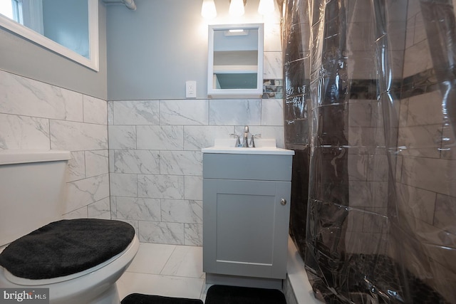 full bathroom featuring vanity, tile walls, toilet, and a shower