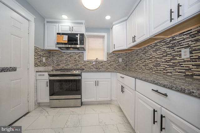 kitchen featuring a sink, decorative backsplash, stainless steel appliances, white cabinetry, and marble finish floor