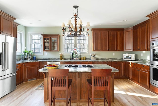 3535 Foxwood Dr, Barboursville, VA 22923 - kitchen with a center island, light wood-style flooring, appliances with stainless steel finishes, a notable chandelier, and a sink