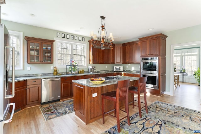 3535 Foxwood Dr, Barboursville, VA 22923 - kitchen featuring a breakfast bar, light wood-style flooring, a center island, stainless steel appliances, and a chandelier