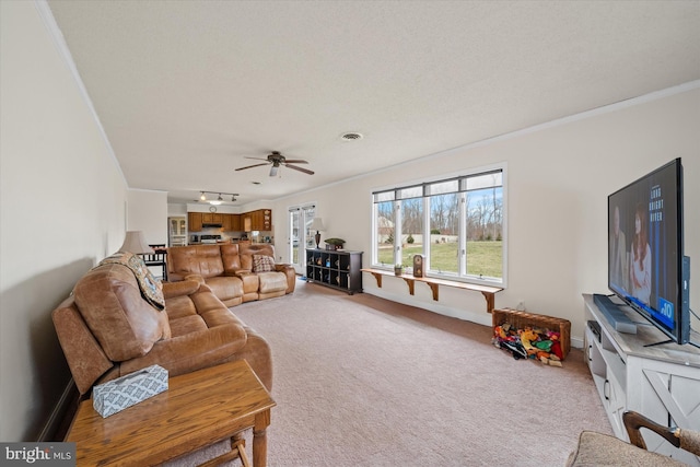 living room featuring light carpet, baseboards, crown molding, and ceiling fan