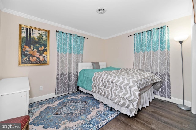 bedroom featuring baseboards, wood finished floors, visible vents, and ornamental molding