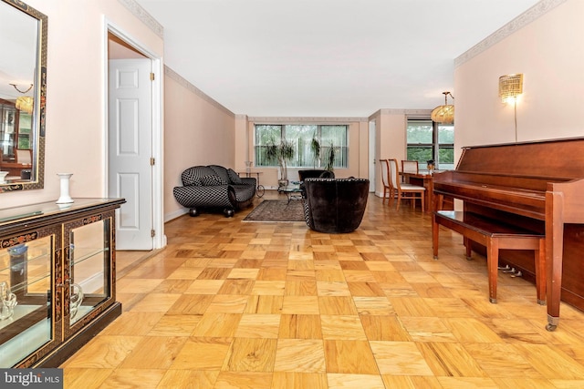 living area with baseboards and ornamental molding