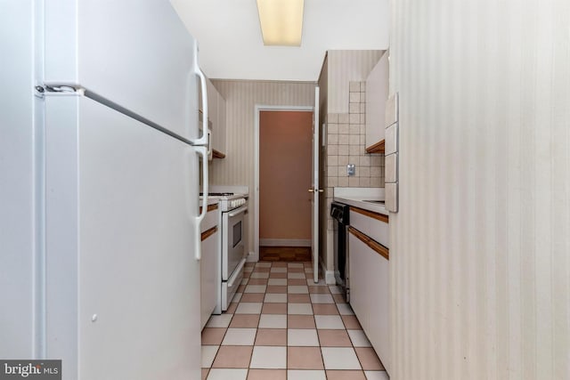 kitchen with white appliances, white cabinets, light tile patterned flooring, and light countertops