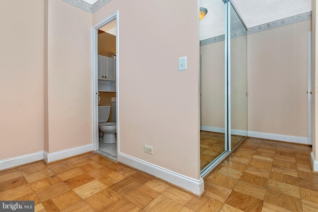 unfurnished bedroom featuring a closet, baseboards, and ensuite bathroom