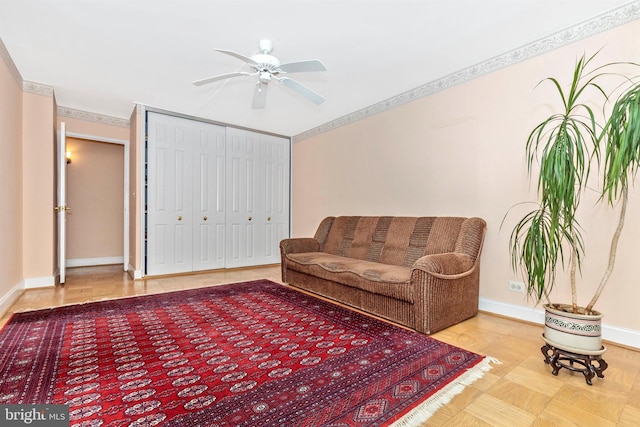 living room with baseboards and a ceiling fan