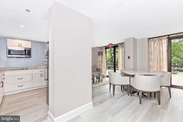 dining room featuring recessed lighting, baseboards, and light wood finished floors