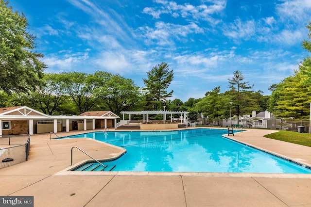 community pool with a patio area, fence, and a pergola