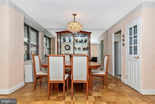 dining area with baseboards and a chandelier